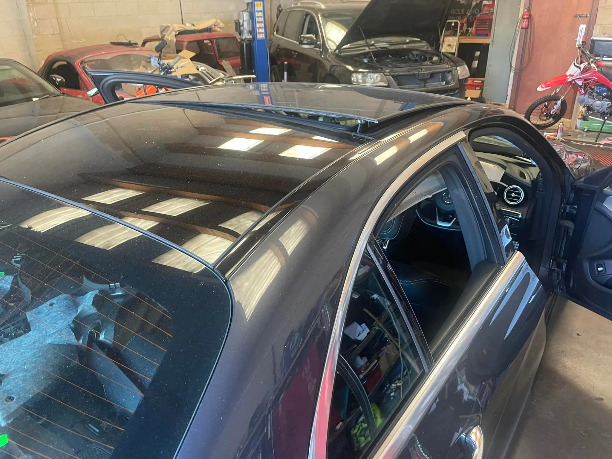 A car with a broken windshield in a garage.