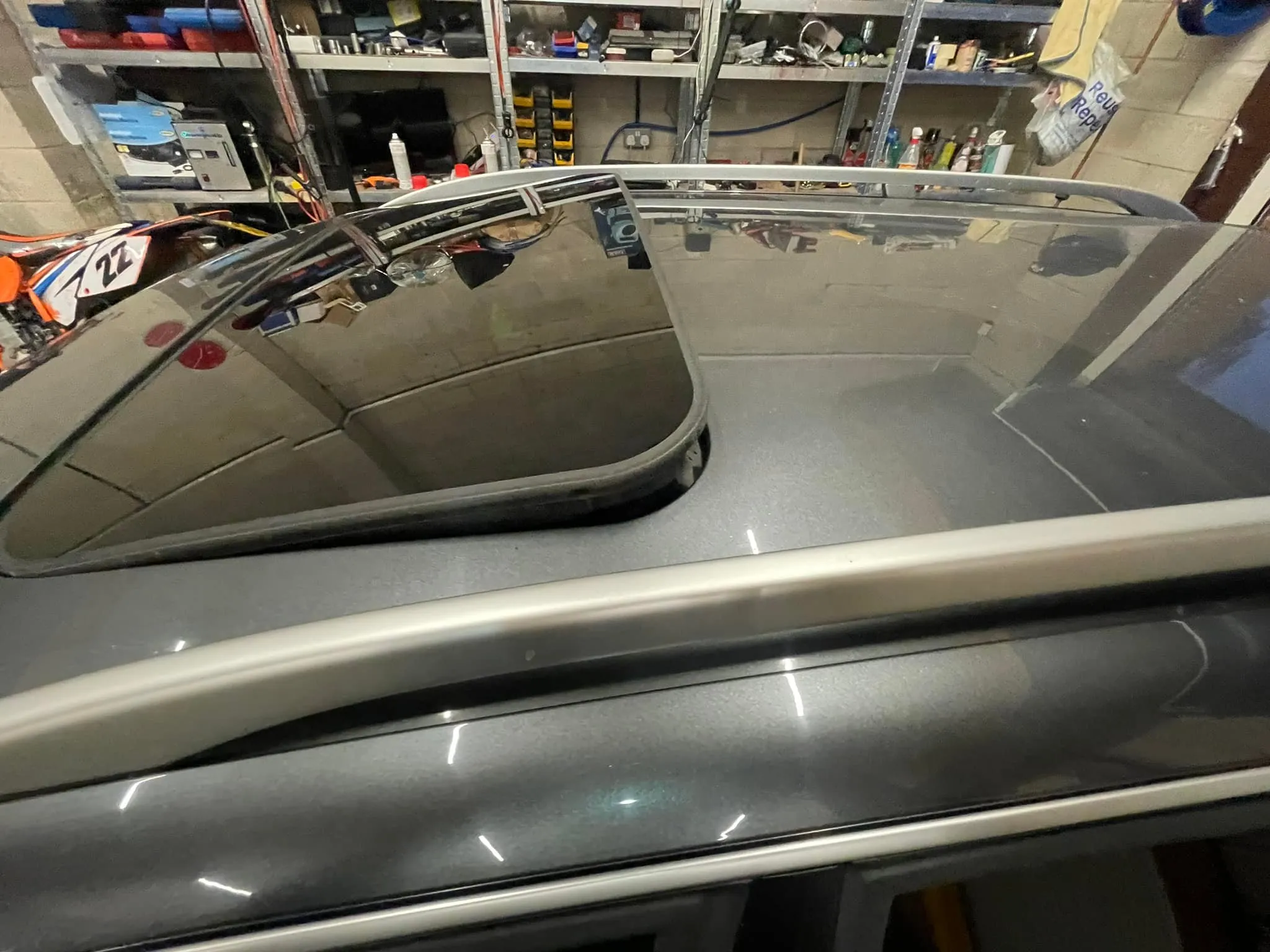 A car's rear view mirror in a garage.