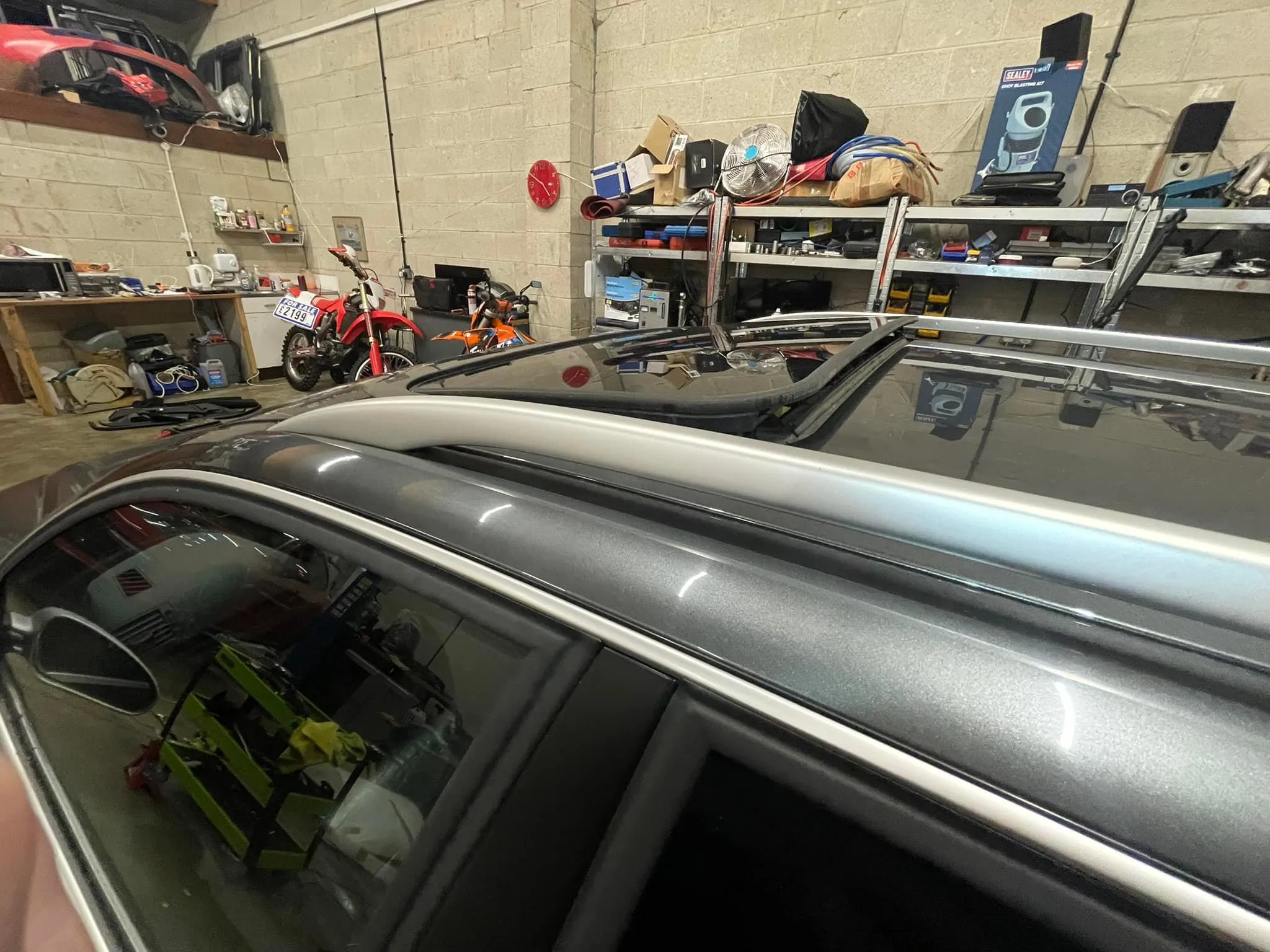 A car is parked in a garage with other cars.