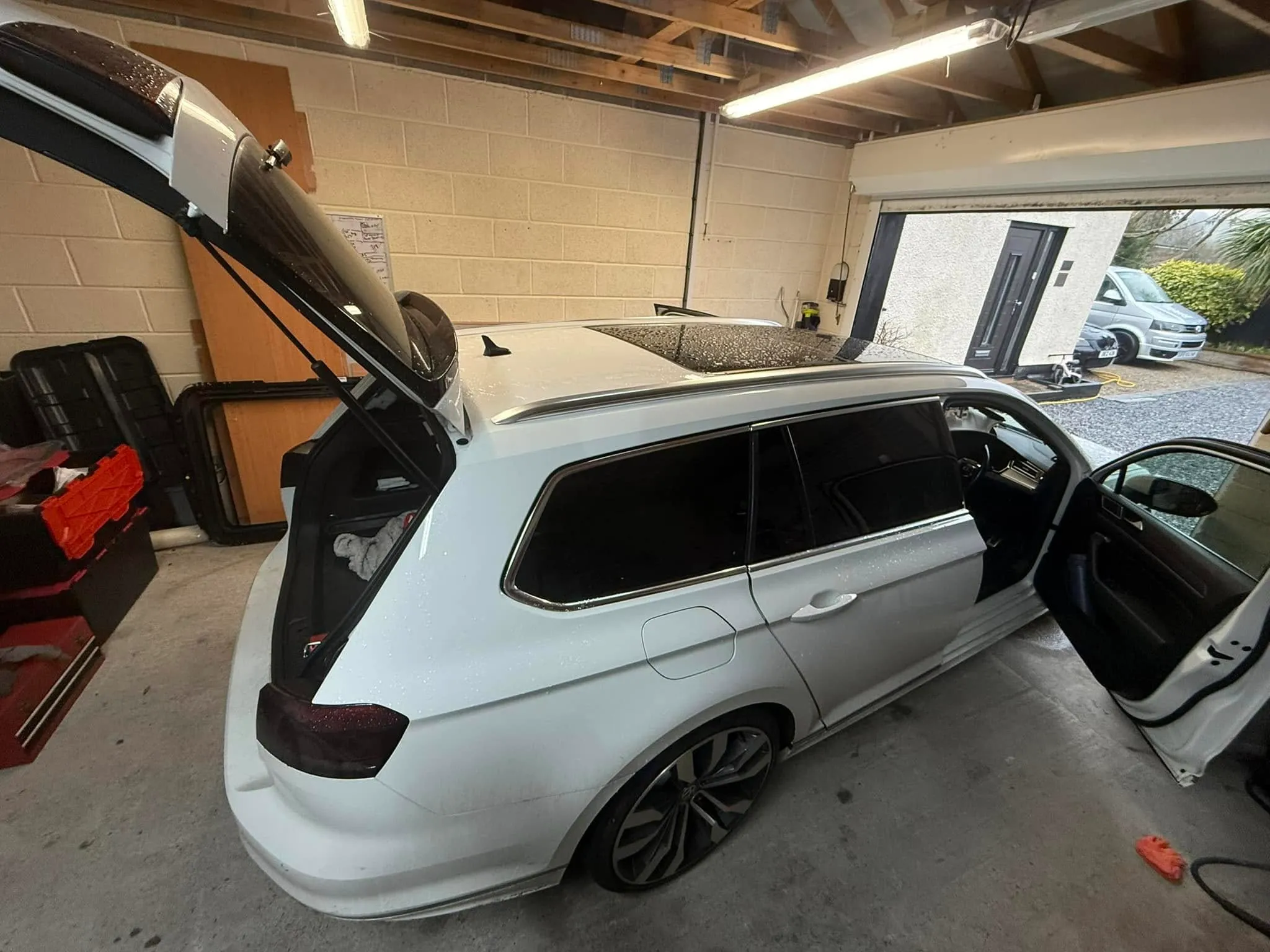 A white car is parked in a garage.